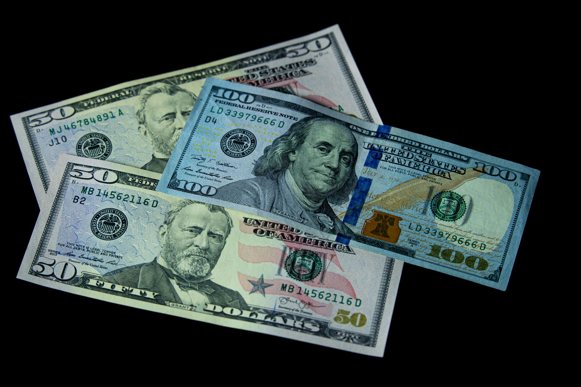 High-quality image of US 50 and 100 dollar bills on a black background, symbolizing wealth and economy. — Best Prop Firms Wit